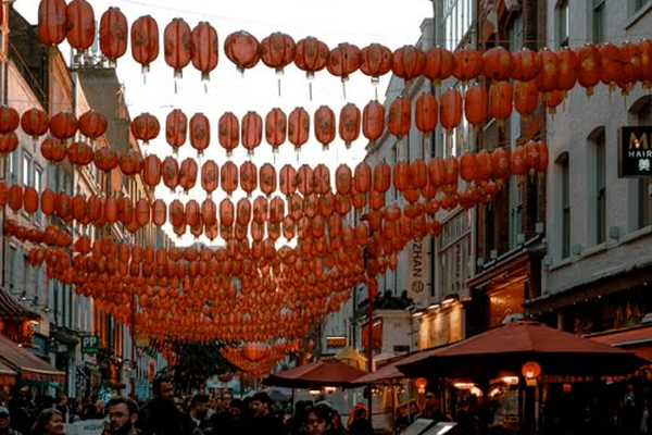 Red Chinese lanterns hanging over a busy street in Chinatown, London