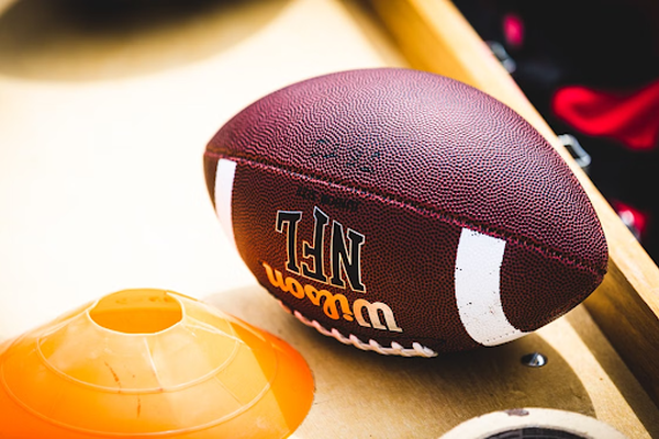 Wilson NFL American football next to an orange training cone