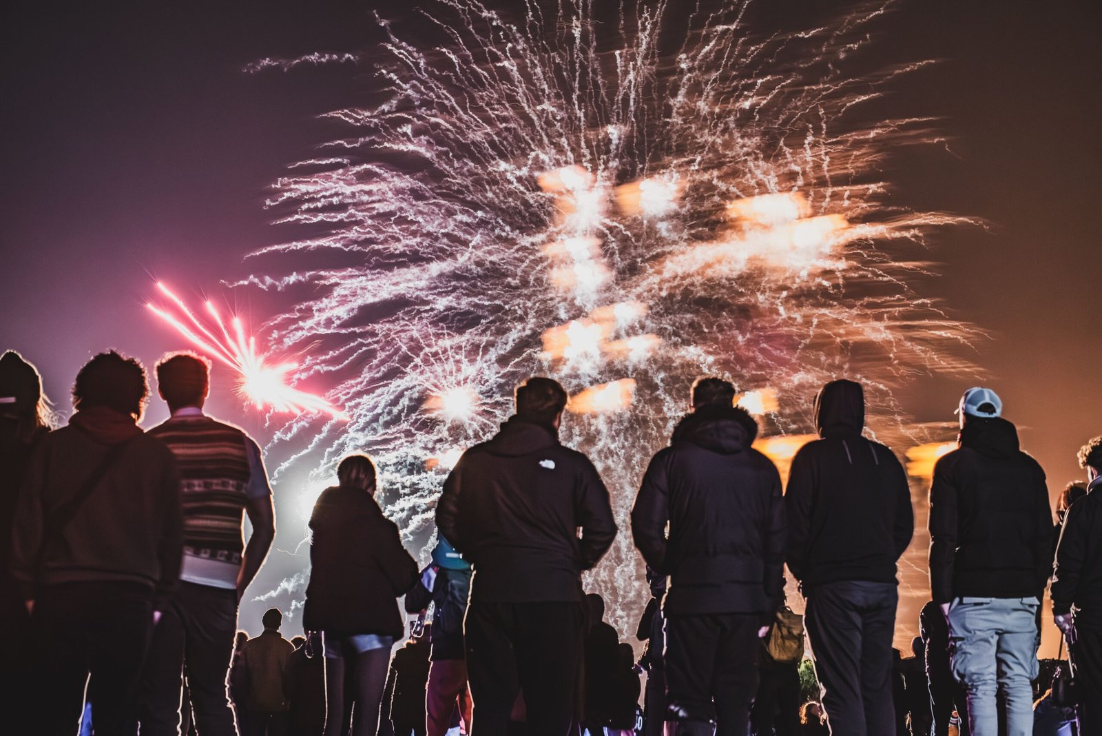 Crowd watching a colourful fireworks display on Bonfire Night